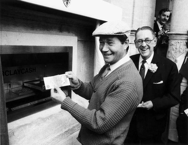 بازیگر رگ وارنی درحال استفاده  از اولین دستگاه پول نقد جهان در بانک بارکلیز، انفیلد، شمال لندن در 27 ژوئن 1967